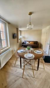 Les Roses - Appartement cosy proche plage - Veules-les-Roses في فول-لي-روز: غرفة معيشة مع طاولة وكراسي وأريكة