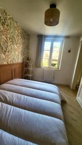 twee bedden in een slaapkamer met een raam bij Les Roses - Appartement cosy proche plage - Veules-les-Roses in Veules-les-Roses