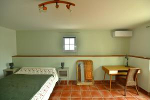 a bedroom with a bed and a table and a mirror at Les Mourguettes in La Celle-sous-Gouzon