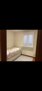 ein kleines Schlafzimmer mit einem Bett und einem Fenster in der Unterkunft Piso en Portugalete in Portugalete