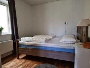 Lovely apartment, perfect for exploring Tjörn and Orust SE09153 في Varekil: سرير عليه وسادتين في غرفة
