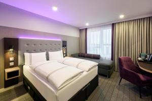 a hotel room with a large bed and a desk at Premier Inn Stuttgart Zuffenhausen in Stuttgart