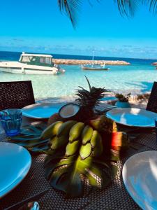 Nautical Nook Maldives في Kendhoo: طاولة عليها أطباق فاكهة فوق المحيط