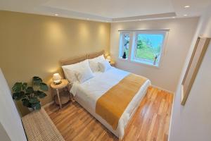 Un dormitorio con una cama grande y una ventana. en Helgøya Hideaway, 