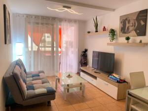 a living room with a couch and a television at Vista de Torre in Costa Del Silencio