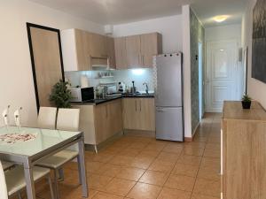 a kitchen with a table and a refrigerator at Vista de Torre in Costa Del Silencio +3 photos