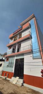 a white building with an orange and white at Hotel Shyam Villa in Ayodhya