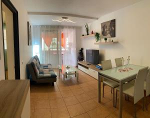 a living room with a table and a dining room at Vista de Torre in Costa Del Silencio