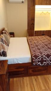 Cama de madera en habitación con ventana en Twin Oaks Kasauli Hills, en Kasauli