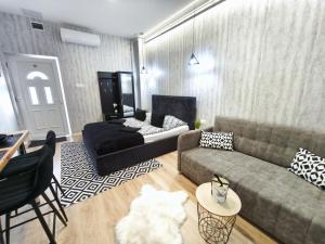 a living room with a couch and a table at Belvárosi Lux Apartman in Vásárosnamény