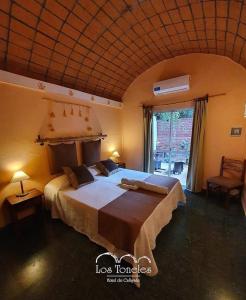 Un dormitorio con una cama grande y una ventana grande. en Toneles - Cafayate, en Cafayate