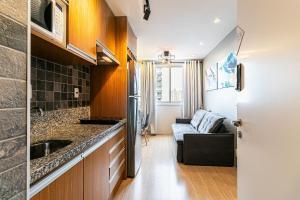 a kitchen and living room with a couch in it at Apto Completo para 6 Hóspedes • Brás, SP in Sao Paulo