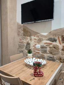 a wooden table with a tv on a stone wall at LETIZIA'S HOME Caserta in Caserta