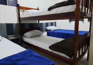 a bedroom with two bunk beds with blue sheets at Pousada Villa in Piquete