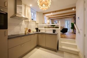 a kitchen with white cabinets and a sink and a chandelier at Appartement C Rosita in Twisk