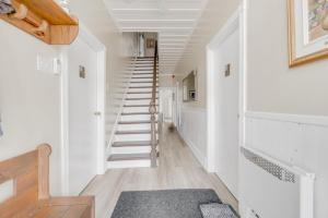 una scala in una casa con pareti bianche e pavimenti in legno di Auberge du vieux pont a Saint-Raymond