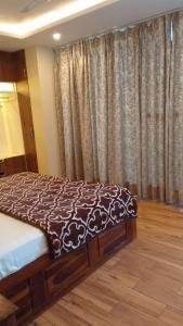 Un dormitorio con una cama y una ventana con cortinas. en Twin Oaks Kasauli Hills, en Kasauli