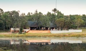 a house on the shore of a body of water at Ilanga Lodge Welgevonden Game Reserve in Welgevonden Game Reserve