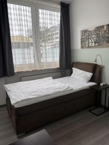 a bed sitting in a room with a window at Franken Motel in Fürth