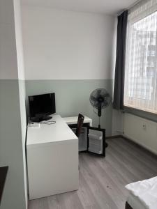 an office with a desk with a computer and a fan at Franken Motel in Fürth