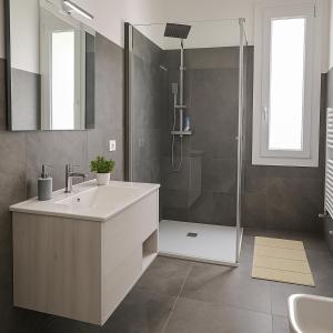 a bathroom with a sink and a shower at Il Giardino di Lilly in Porlezza