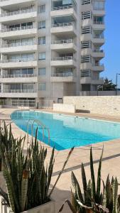 een zwembad voor een groot gebouw bij Serena Mar La Serena in La Serena