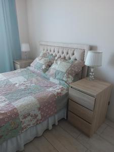 een slaapkamer met een bed en een nachtkastje met een lamp bij Serena Mar La Serena in La Serena
