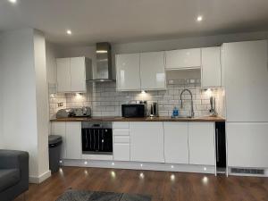 a kitchen with white cabinets and a counter top at Nottingham Central Accommodation in Nottingham