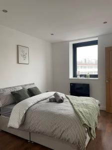 een witte slaapkamer met een bed en een raam bij Forest Gate Nest Nottingham in Nottingham