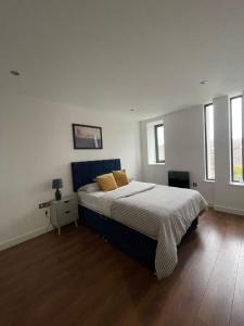 een slaapkamer met een groot bed en twee ramen bij Forest Gate Nest Nottingham in Nottingham