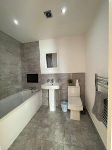 een badkamer met een bad, een wastafel en een toilet bij Forest Gate Nest Nottingham in Nottingham