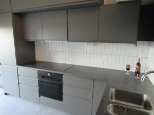 Newly built cottage near the sea and nature in Henån SE09152 في Näset: مطبخ بدولاب رمادي ومغسلة ومكتب +20 صورة