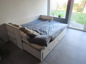 Newly built cottage near the sea and nature in Henån SE09152 في Näset: سرير في غرفة ذات نافذة كبيرة