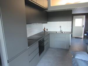 Newly built cottage near the sea and nature in Henån SE09152 في Näset: مطبخ مع حوض وموقد