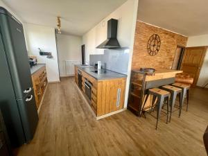 a kitchen with a counter and a table with stools at COAST HOUSE Havenquartier in Bremerhaven