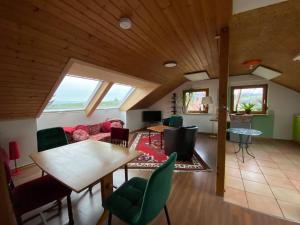 a living room with a table and green chairs at Burgblick Stube - Apartment für bis zu 4 Personen - Haustiere willkommen - mit Einbauküche - Fahrradparkplatz etc in Beilstein