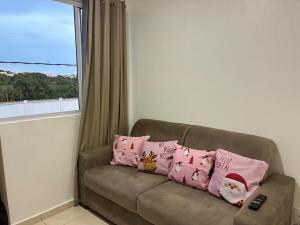 マナウスにあるsmart torquatoの窓のある、ピンクの枕が置かれたソファ