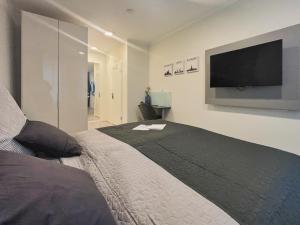 a bedroom with a large bed and a flat screen tv at HAVENU Hotel Quartier 8 in Germersheim