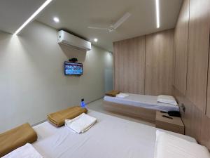 NP Residency في كومباكونام: غرفة بها سريرين وتلفاز على الحائط +14 صورة