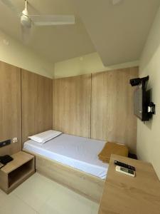 NP Residency في كومباكونام: غرفة نوم صغيرة مع سرير وتلفزيون