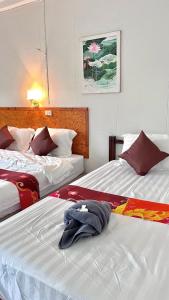 two beds sitting next to each other in a bedroom at Book Lanta House in Ban Ru Yai