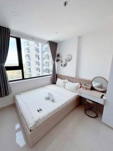 a bedroom with a large bed and a window at Tom's House Apartment 1 in Thôn Văn Dương