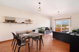 een eetkamer en woonkamer met een tafel en stoelen bij Tamara's Apartment in Armação de Pêra