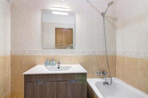 een badkamer met een wastafel, een bad en een spiegel bij Tamara's Apartment in Armação de Pêra +14 foto's