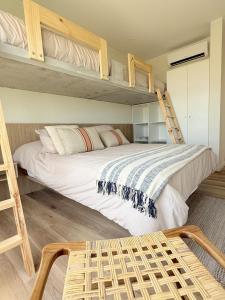 Apartamento Vista Reserva y Playa en Paracas في Santo Domingo: غرفة نوم بسريرين بطابقين وكرسي