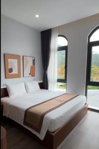 Un dormitorio con una cama grande y una ventana. en Kapás Hotel, en Hai Phong