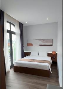 Un dormitorio con una cama y una ventana grande. en Kapás Hotel, en Hai Phong
