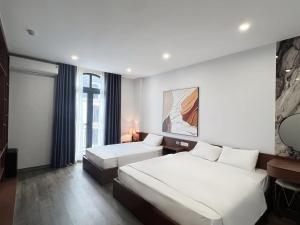 Una habitación de hotel con dos camas y una ventana. en Kapás Hotel, en Hai Phong
