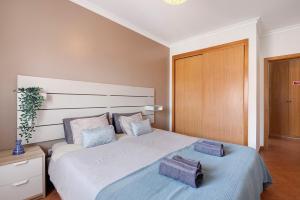 een slaapkamer met een groot bed met twee kussens erop bij Tamara's Apartment in Armação de Pêra