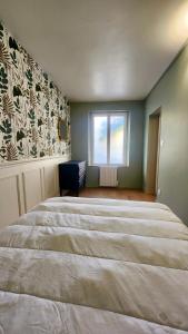 Le Moulin - Appartement cosy proche plage - Veules-les-Roses في فول-لي-روز: سرير كبير في غرفة مع نافذة